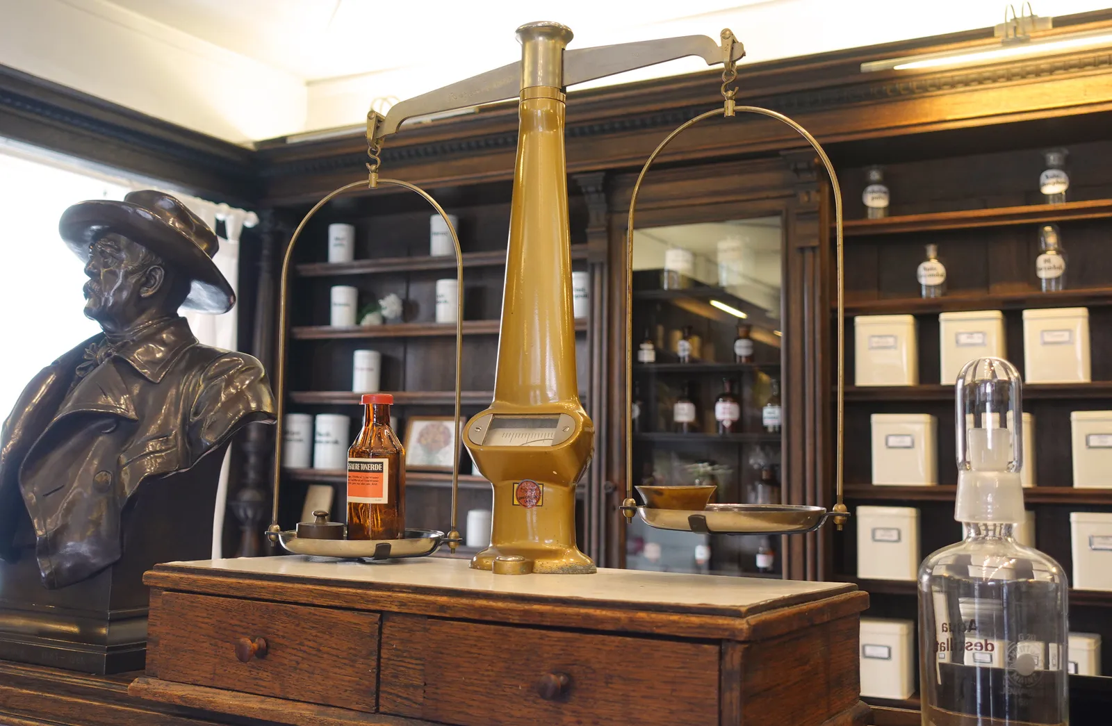 Historische Offizin der Fürst Bismarck-Apotheke mit dunklem Holzmobiliar und Glasvitrinen